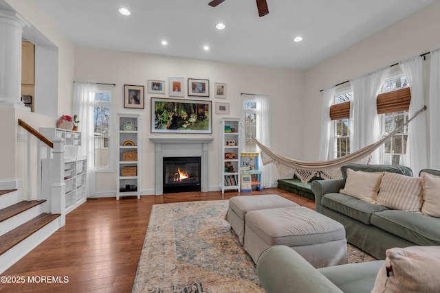 living room with recessed lighting, stairway, a glass covered fireplace, ceiling fan, and hardwood / wood-style floors