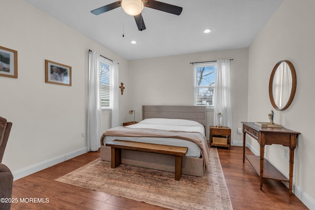 bedroom featuring multiple windows, wood finished floors, and baseboards