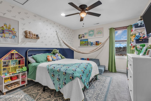 carpeted bedroom with wallpapered walls, baseboards, visible vents, and a ceiling fan