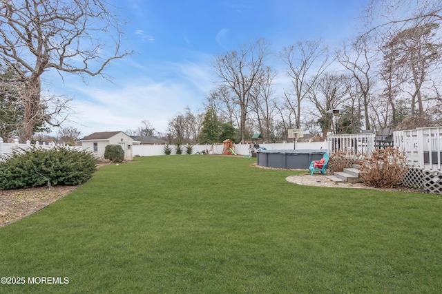 view of yard with a deck, an outdoor structure, a fenced backyard, and a fenced in pool