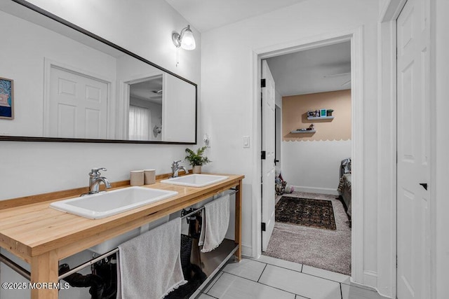 full bath with double vanity, tile patterned flooring, and a sink