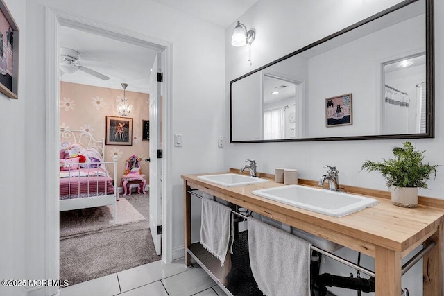 bathroom with connected bathroom, a sink, ceiling fan, and tile patterned floors