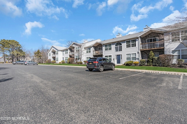 view of building exterior featuring uncovered parking and a residential view