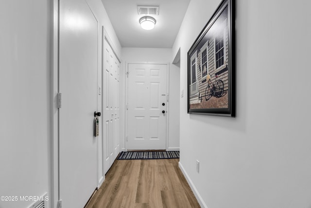 entryway featuring baseboards, visible vents, and wood finished floors