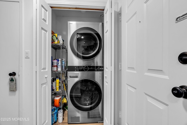 washroom with laundry area, wood finished floors, and stacked washer / drying machine