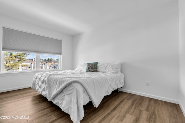 bedroom featuring wood finished floors and baseboards