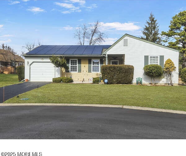 ranch-style house featuring aphalt driveway, a front lawn, and an attached garage