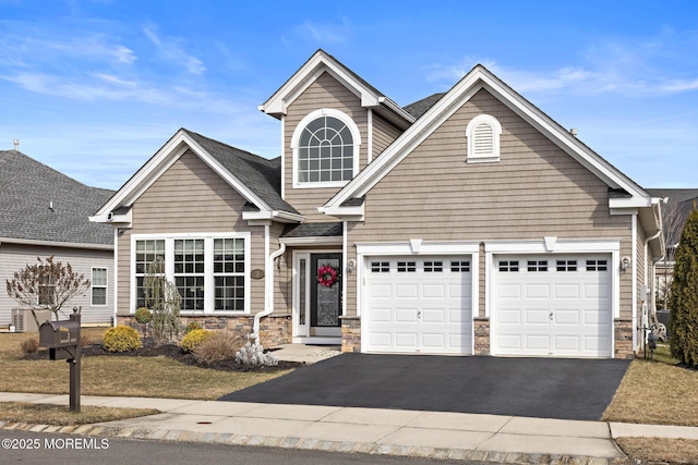 view of front of property featuring a garage, stone siding, roof with shingles, and driveway