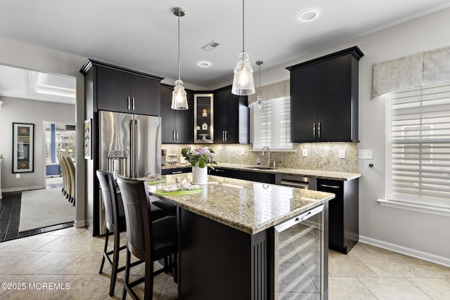 kitchen with beverage cooler, backsplash, and dark cabinets