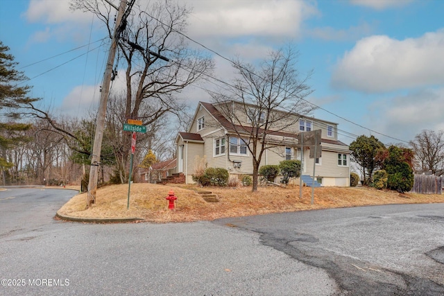 view of front of property with aphalt driveway and fence