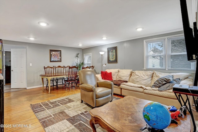 living room featuring crown molding, baseboards, wood finished floors, and recessed lighting