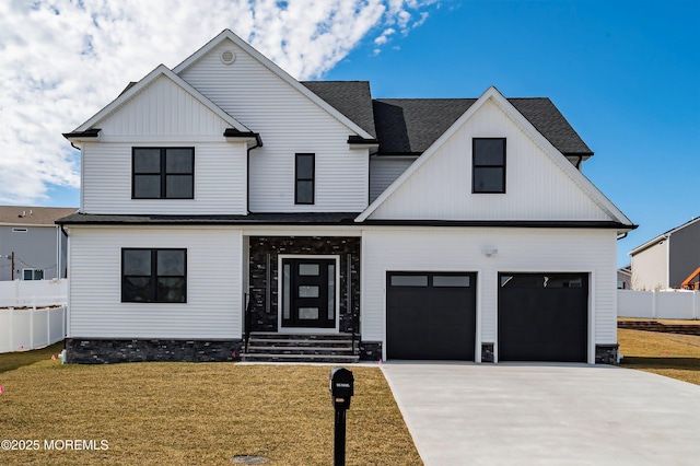 modern farmhouse with board and batten siding, a shingled roof, a front lawn, fence, and concrete driveway