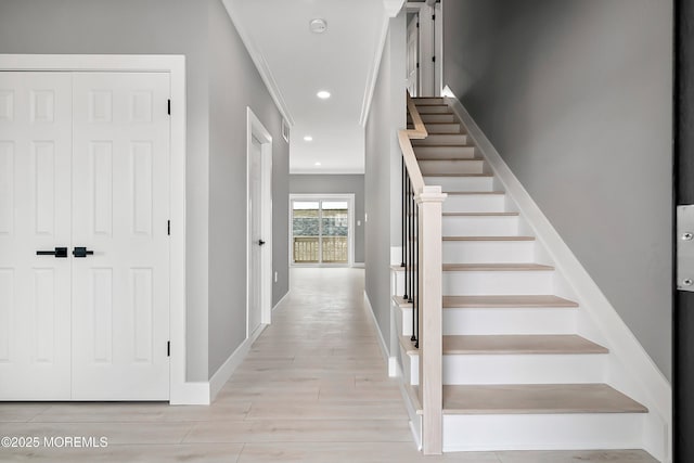 stairway featuring recessed lighting, crown molding, baseboards, and wood finished floors