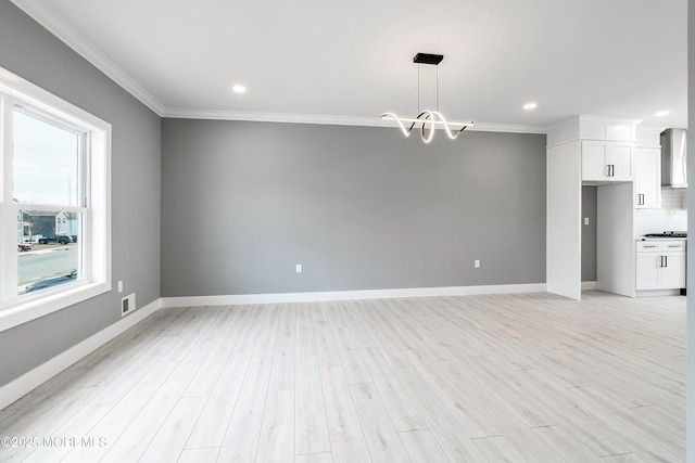 interior space featuring crown molding, baseboards, and light wood finished floors