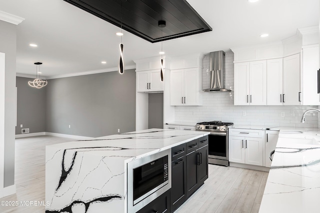 kitchen with a kitchen island, ornamental molding, stainless steel appliances, wall chimney exhaust hood, and backsplash