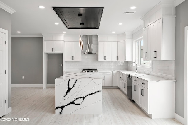 kitchen with visible vents, a kitchen island, wall chimney range hood, light stone counters, and stainless steel dishwasher