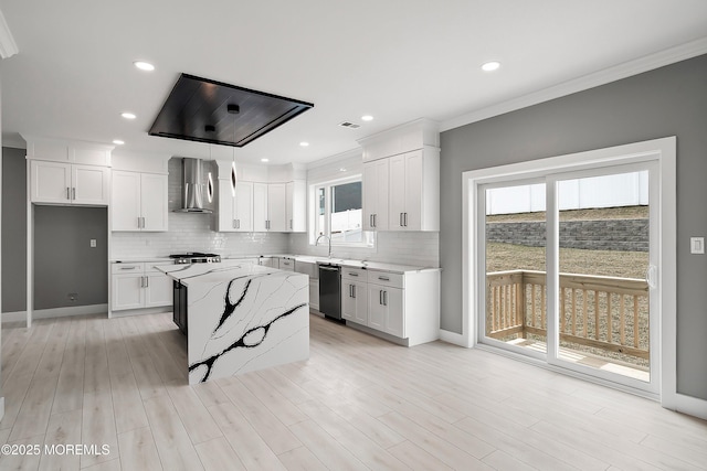 kitchen featuring dishwashing machine, wall chimney range hood, light stone counters, and white cabinets