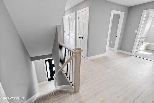 stairway featuring wood finished floors and baseboards