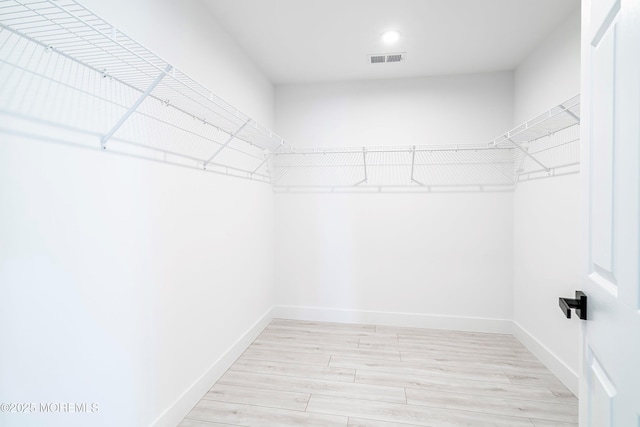 spacious closet featuring visible vents and wood finished floors