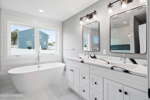 bathroom with a walk in shower, a freestanding bath, double vanity, marble finish floor, and a sink