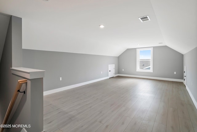 bonus room with light wood finished floors, visible vents, lofted ceiling, and baseboards