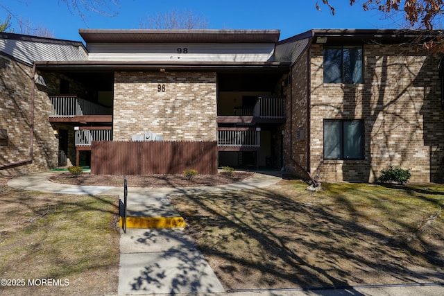 exterior space featuring brick siding and a balcony