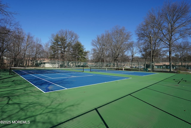 view of tennis court featuring fence