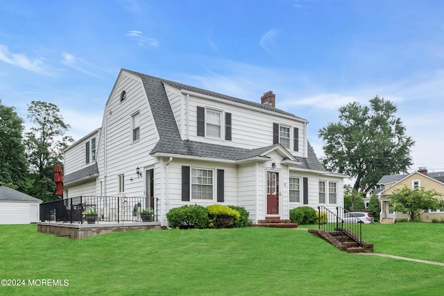 dutch colonial with entry steps, a shingled roof, a gambrel roof, a chimney, and a front yard