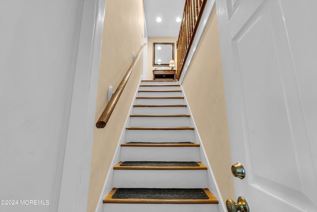 stairway with recessed lighting and baseboards