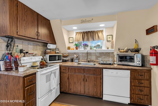 kitchen with white appliances, backsplash, a sink, and a toaster