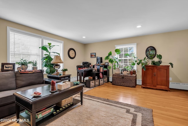 living area featuring a baseboard heating unit, recessed lighting, light wood-style flooring, and baseboards