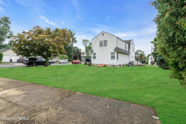 view of property exterior featuring central air condition unit, a yard, and a gambrel roof