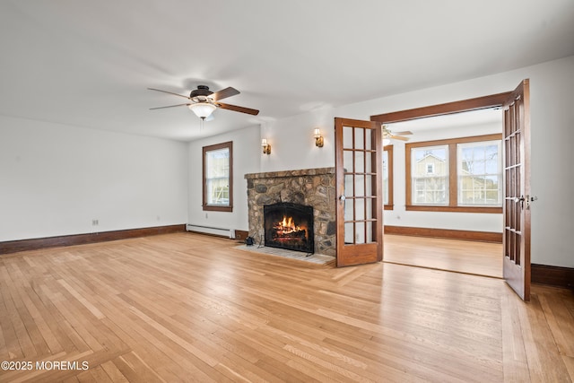 unfurnished living room featuring light wood-type flooring and a stone fireplace