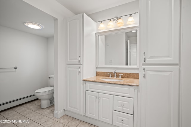 bathroom featuring toilet, vanity, a baseboard heating unit, and tile patterned floors