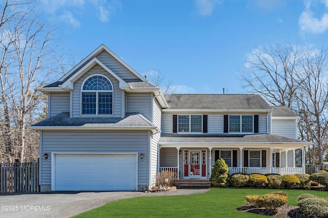 view of front of property with driveway, an attached garage, fence, a porch, and a front yard