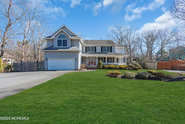 view of front of home with driveway, an attached garage, covered porch, fence, and a front lawn