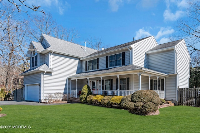 view of front of house featuring a garage, a front lawn, fence, and a porch