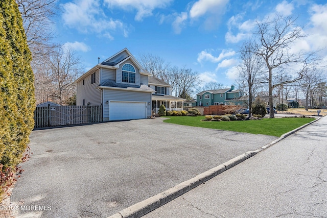 view of front of house featuring aphalt driveway, a front yard, fence, and an attached garage