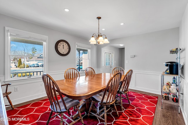 dining area with arched walkways, a wainscoted wall, wood finished floors, a chandelier, and recessed lighting