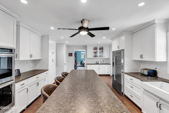 kitchen featuring stainless steel appliances, dark wood-style flooring, recessed lighting, and white cabinets