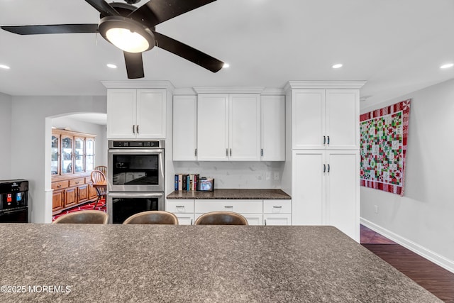 kitchen with double oven, recessed lighting, white cabinets, and dark wood-style floors