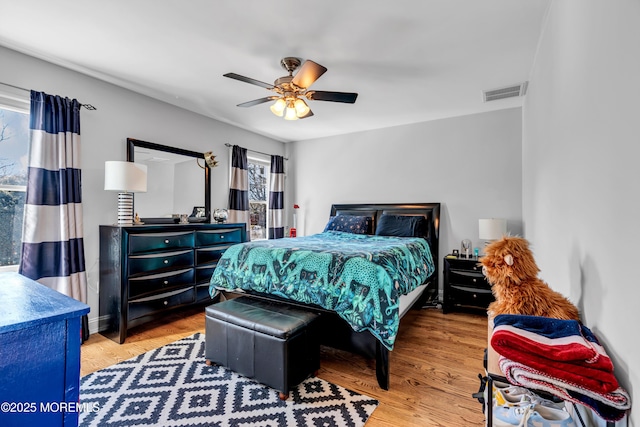 bedroom featuring visible vents, ceiling fan, and light wood-style flooring