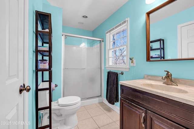 bathroom featuring vanity, a shower stall, toilet, and tile patterned floors