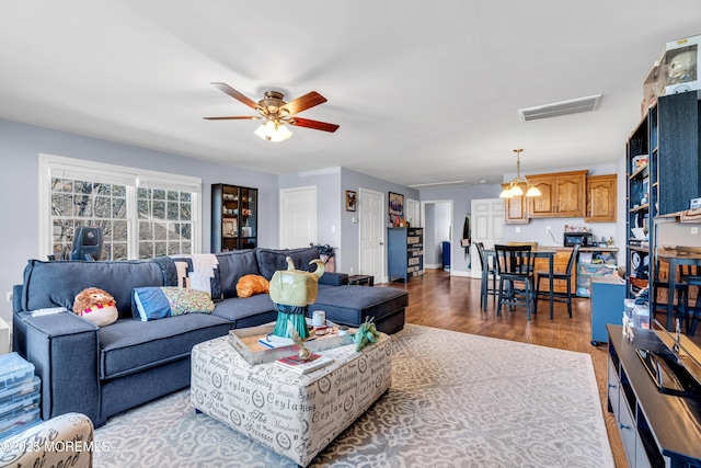 living room featuring visible vents, ceiling fan, baseboards, and wood finished floors