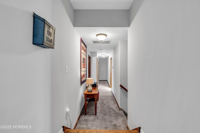 corridor featuring light carpet, visible vents, baseboards, and an upstairs landing