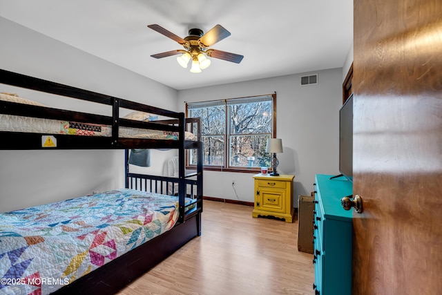 bedroom with light wood-style floors, baseboards, and visible vents