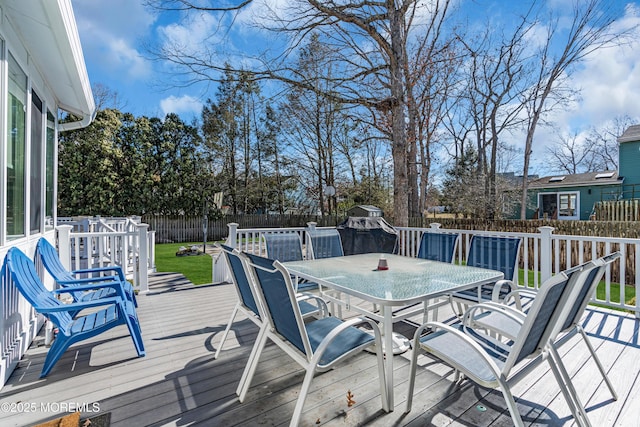 wooden deck with outdoor dining space and a fenced backyard