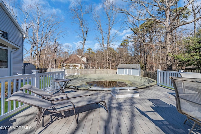 deck featuring an outbuilding, a fenced backyard, and a storage unit