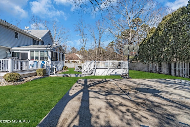 view of yard featuring a sunroom, fence, and a wooden deck