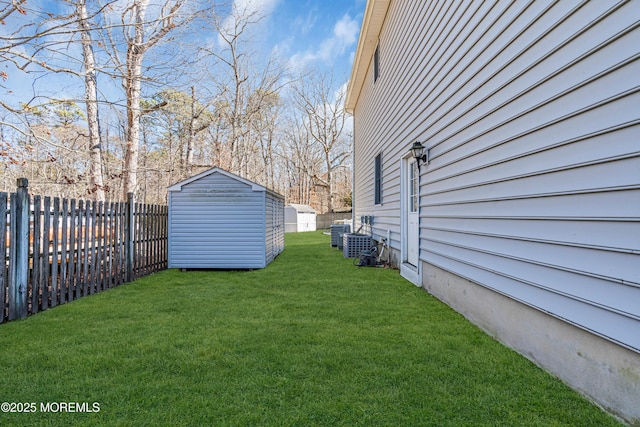 view of yard with an outbuilding, a shed, and a fenced backyard